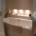 Bathroom in limestone with discreet lighting in addition to ceiling fixtures
