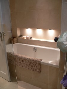 Bathroom in limestone with discreet lighting in addition to ceiling fixtures